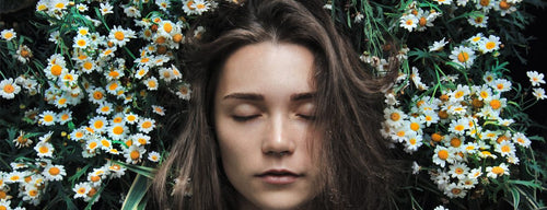 woman sleeping well in a bed of daisies