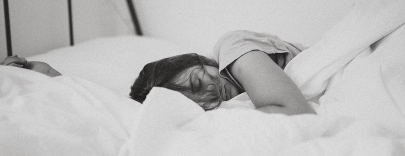 woman sleeping in bed in black and white image