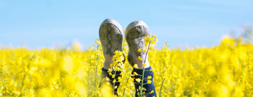 woman with hay fever with feet in the air in a field