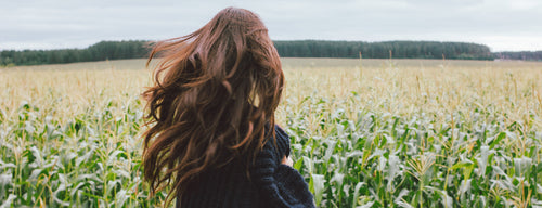 woman with beautiful natural hair in field