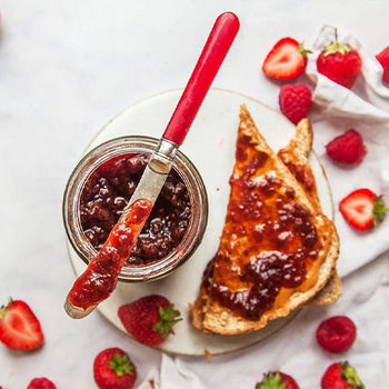 strawberry jam on toast surrounded by fresh strawberries