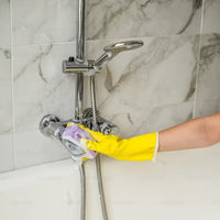 cleaning a shower with gloves and sponge