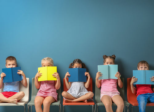 kids peeking out from behind books sitting against a blue background