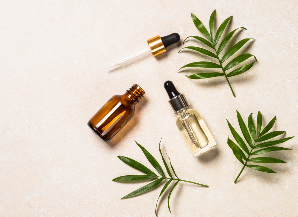 bottles of facial oil and serum on neutral background