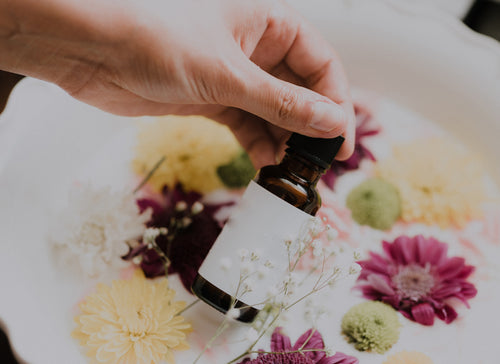 hand holding glass bottle with flowers