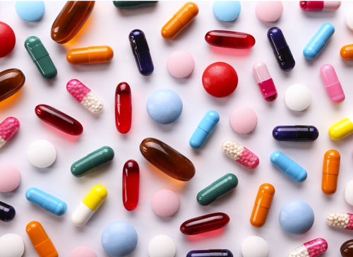Antioxidant Supplements colourful tablets and capsules on white background