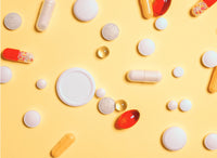vitamin d supplements tablets and capsules on yellow background