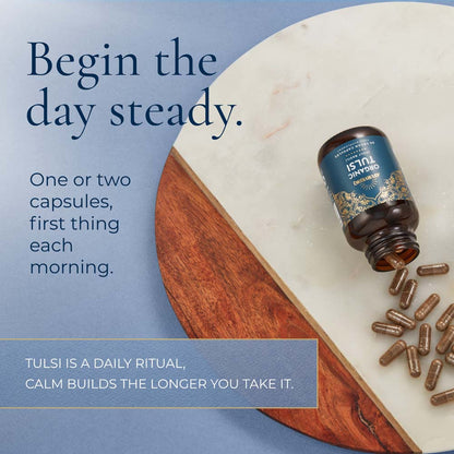 A bottle of Tulsi 15mg Standardized Extract capsules lies on a white marble board with several capsules spilled out onto a blue surface. Large text reads, &