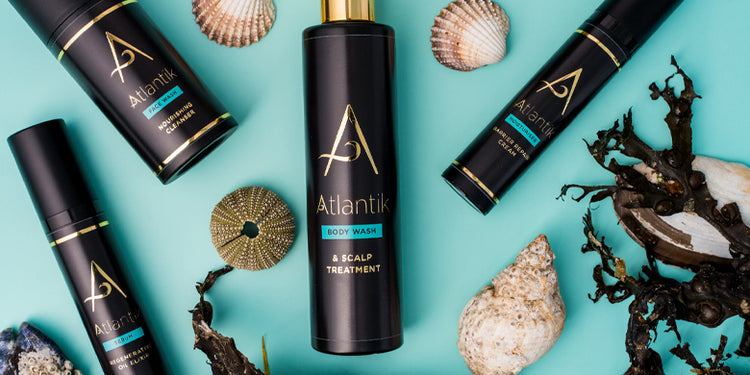 Atlantik skincare products with natural elements on a teal background