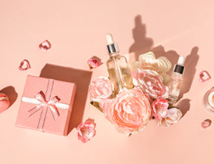 bottles of skin oil with flowers on a pink background