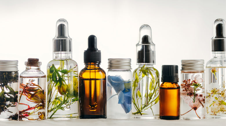 Selection of glass dropper bottles with botanical flowers suspended in clear liquid