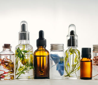Selection of glass dropper bottles with botanical flowers suspended in clear liquid