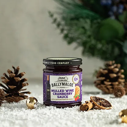 Jar of Ballymaloe Mulled Wine Cranberry Sauce with decorative elements on a textured surface.