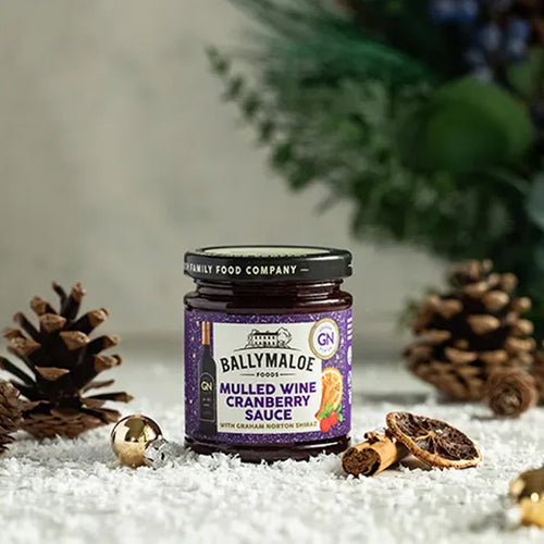Jar of Ballymaloe Mulled Wine Cranberry Sauce with decorative elements on a textured surface.