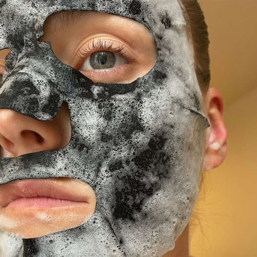 Person wearing a black and gray facial mask with a blurred background