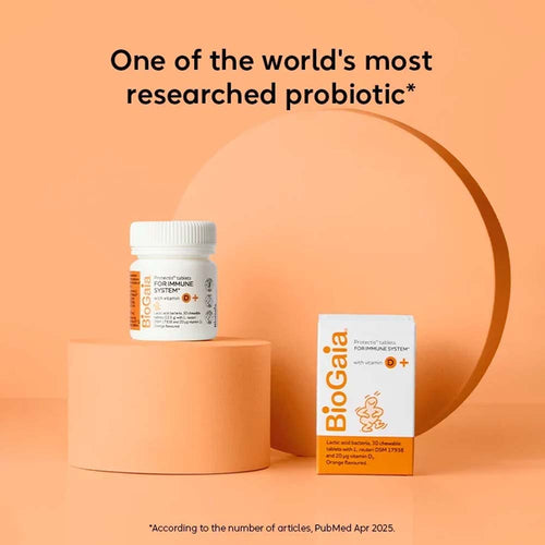BioGaia Probiotic supplement shown with a white bottle and white-and-orange box on peach-colored pedestals against a peach background, with the headline &
