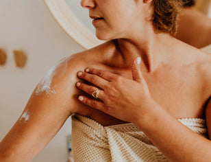 Woman applying body lotion