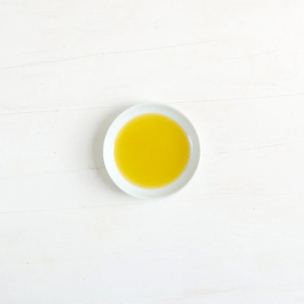 A small white round dish filled with Clearspring olive oil.