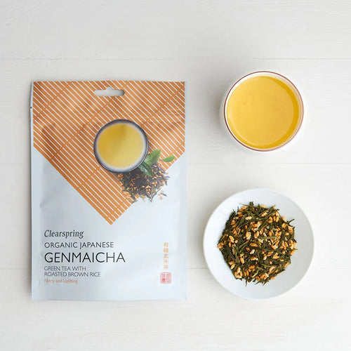 Clearspring Organic Japanese Genmaicha packaging with a cup of tea and a bowl of green tea leaves on a white background
