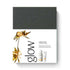 Dr. Hauschka Glow Radiance Ritual set packaging, featuring a dark charcoal gray top section and a white bottom section with gold botanical illustrations and product tubes.