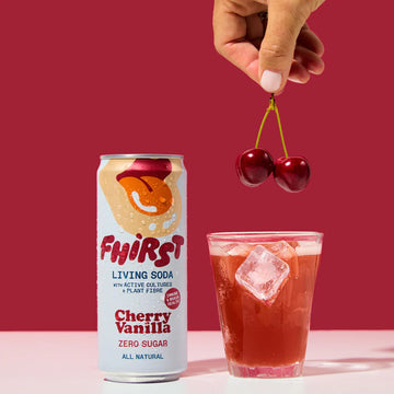 Fhirst Cherry Vanilla Living Soda in a glass with fresh cherries