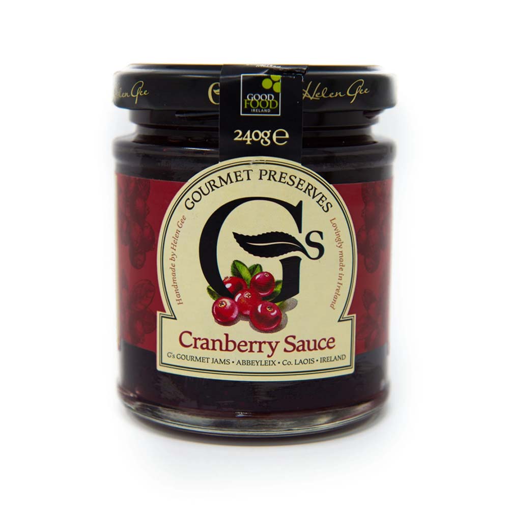 A glass jar of Good Food Centre Gourmet Preserves Cranberry Sauce, featuring a cream and red label with cranberry illustrations and a black lid.