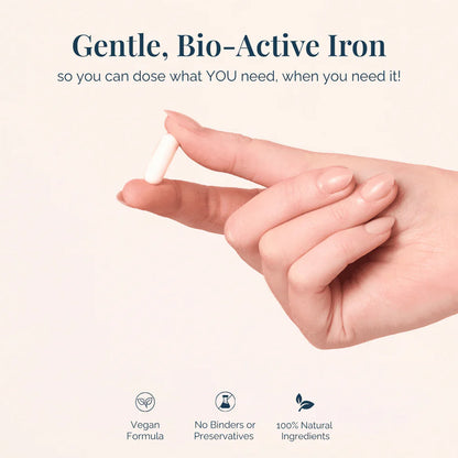 Hand holding a small iron supplement with promotional text about gentle, bio-active iron on a light background.
