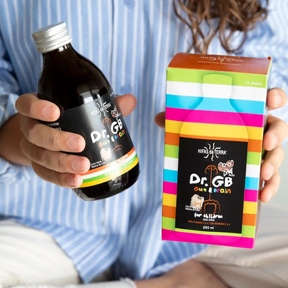Person holding a bottle and colorful box of Dr. GB Gut Brain supplement.