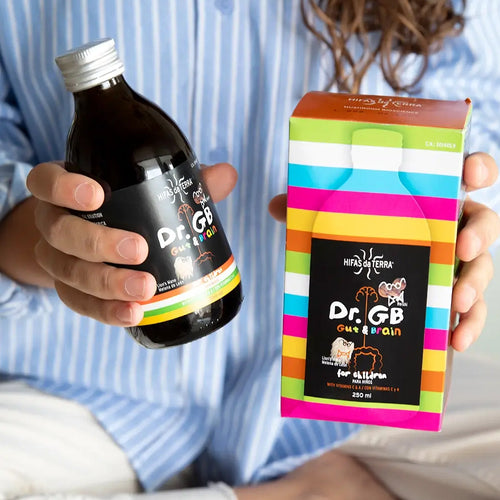 Person holding a bottle and colorful box of Dr. GB Gut Brain supplement.