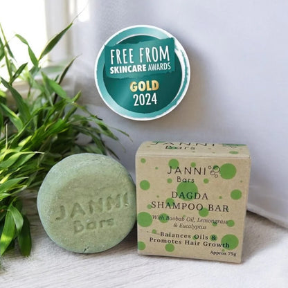 Janni Bars shampoo bar and packaging with a plant and award badge in the background