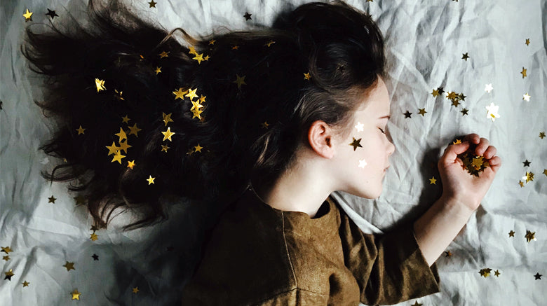 Girl sleeping with golden stars across face and hair