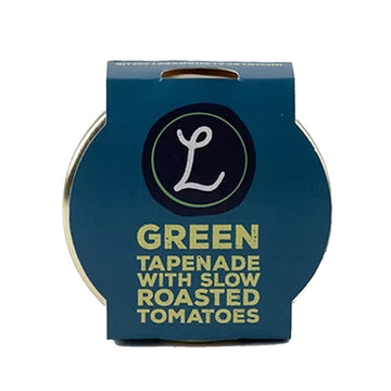 Blue container of green tapenade with slow roasted tomatoes on a white background