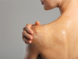 Woman applying body scrub gel