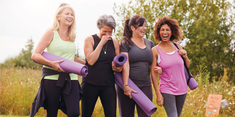 group of smiling women in workout gear walking