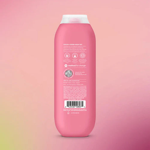 Pink shampoo bottle with label on a pink gradient background