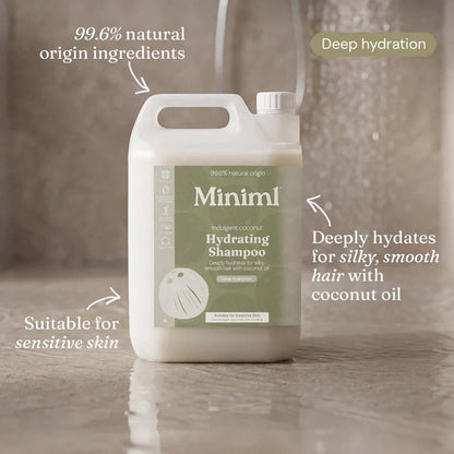 A large white plastic bottle of Minim1 Hydrating Shampoo with a sage green label, shown on a glossy tiled floor with marketing text callouts around it.