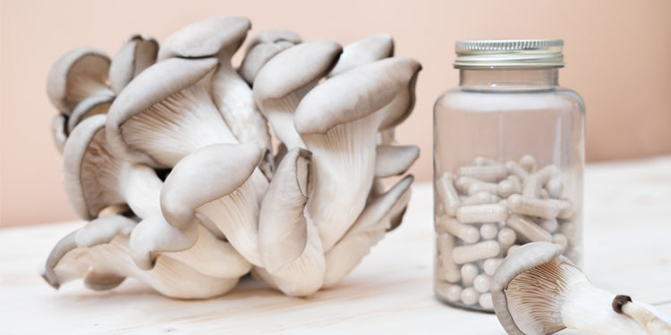 Medicinal mushrooms in a supplement bottle with raw mushrooms on beige background