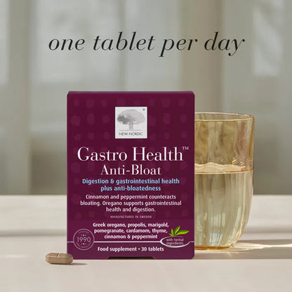 Gastro Health Anti-Bloat supplement packaging with a glass of water on a neutral background