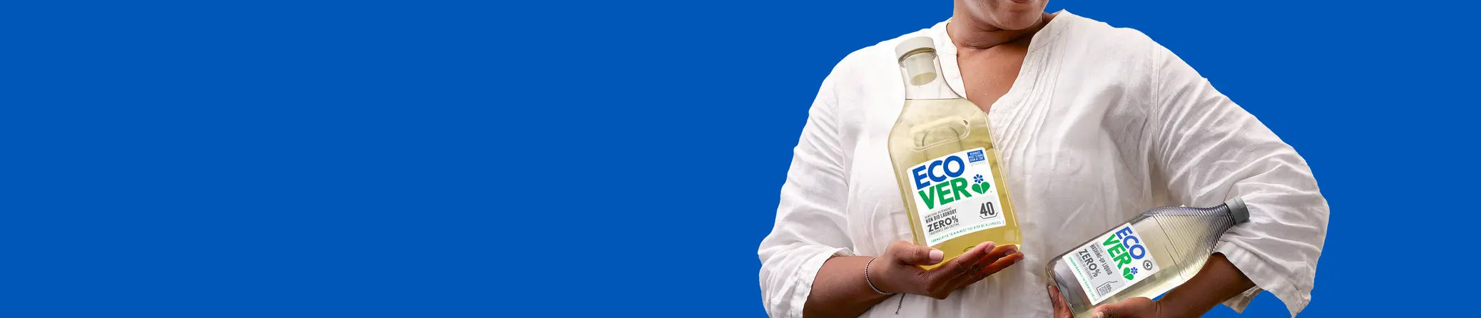 Person holding two bottles of Ecover against a blue background