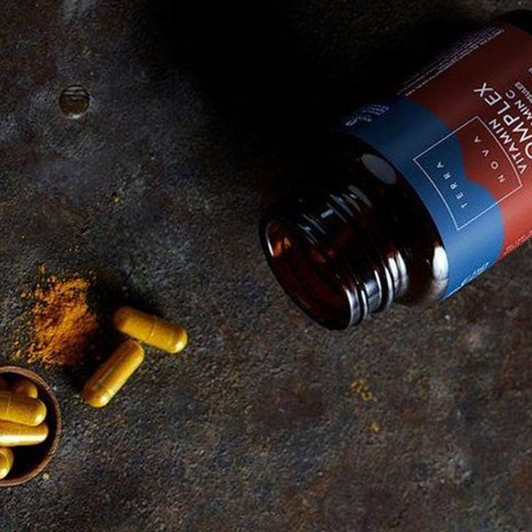Bottle of terranova on a dark surface with spices and leaves