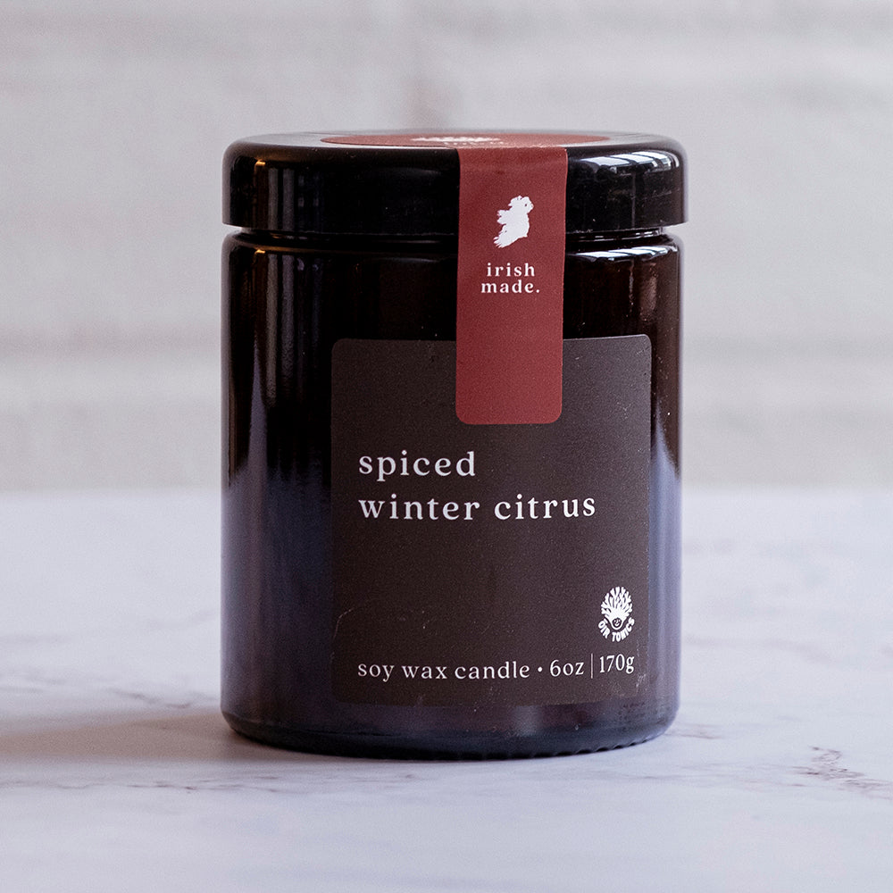 A black jar candle with a label that reads &