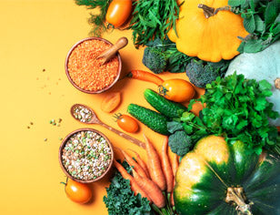 range of colourful organic food on yellow background