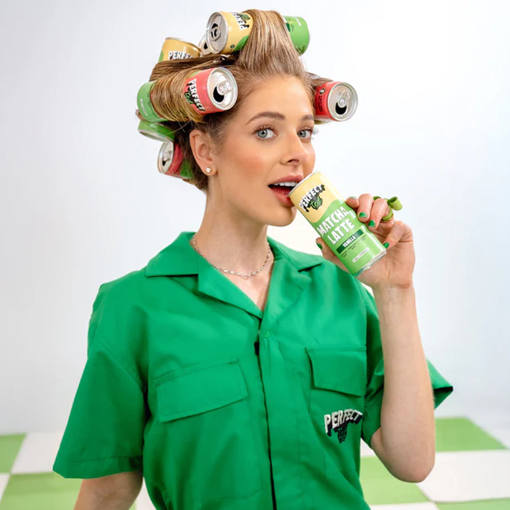 Woman with hair in rollers holding a can of Perfect Drink, wearing a green shirt.