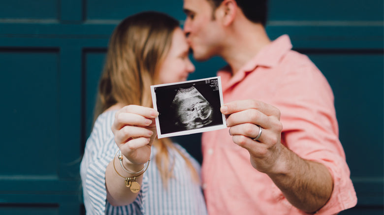 Woman and man holding ultrasound scan picture
