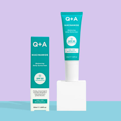 Q+A Niacinamide SPF 50 Balancing Daily Sunscreen with colourful background