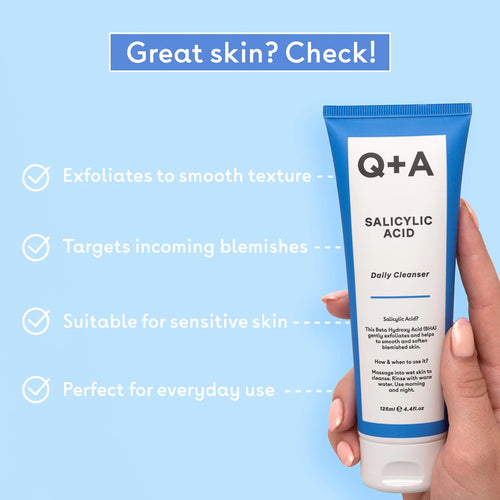 Q+A Salicylic Acid Daily Cleanser tube held by a hand with text on a blue background