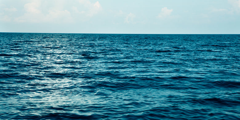 Calm blue sea with sun reflecting on the waves