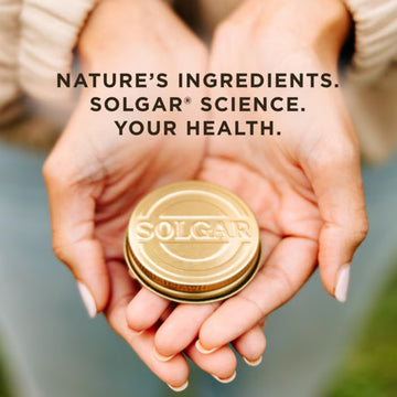 Hands holding Solgar supplement container lid.
