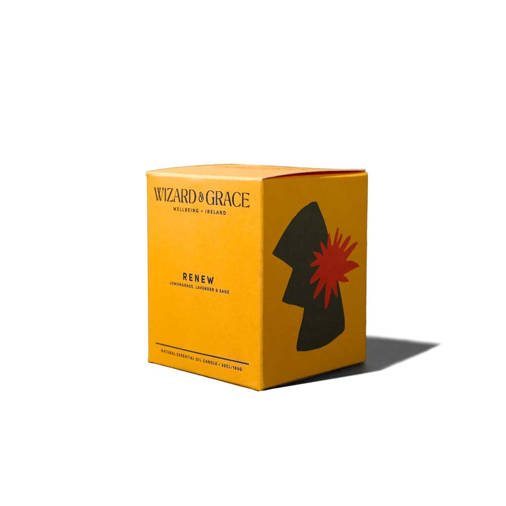 Warm yellow packaging box for the Wizard &amp; Grace "RENEW" natural essential oil candle, featuring dark olive green and orange abstract botanical illustrations on a clean white background.