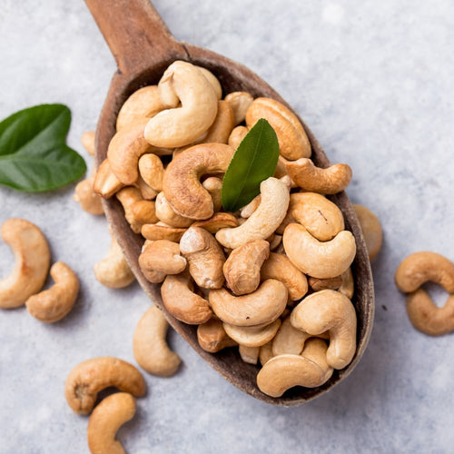 True Natural Goodness Organic Cashew Nuts on wooden spoon